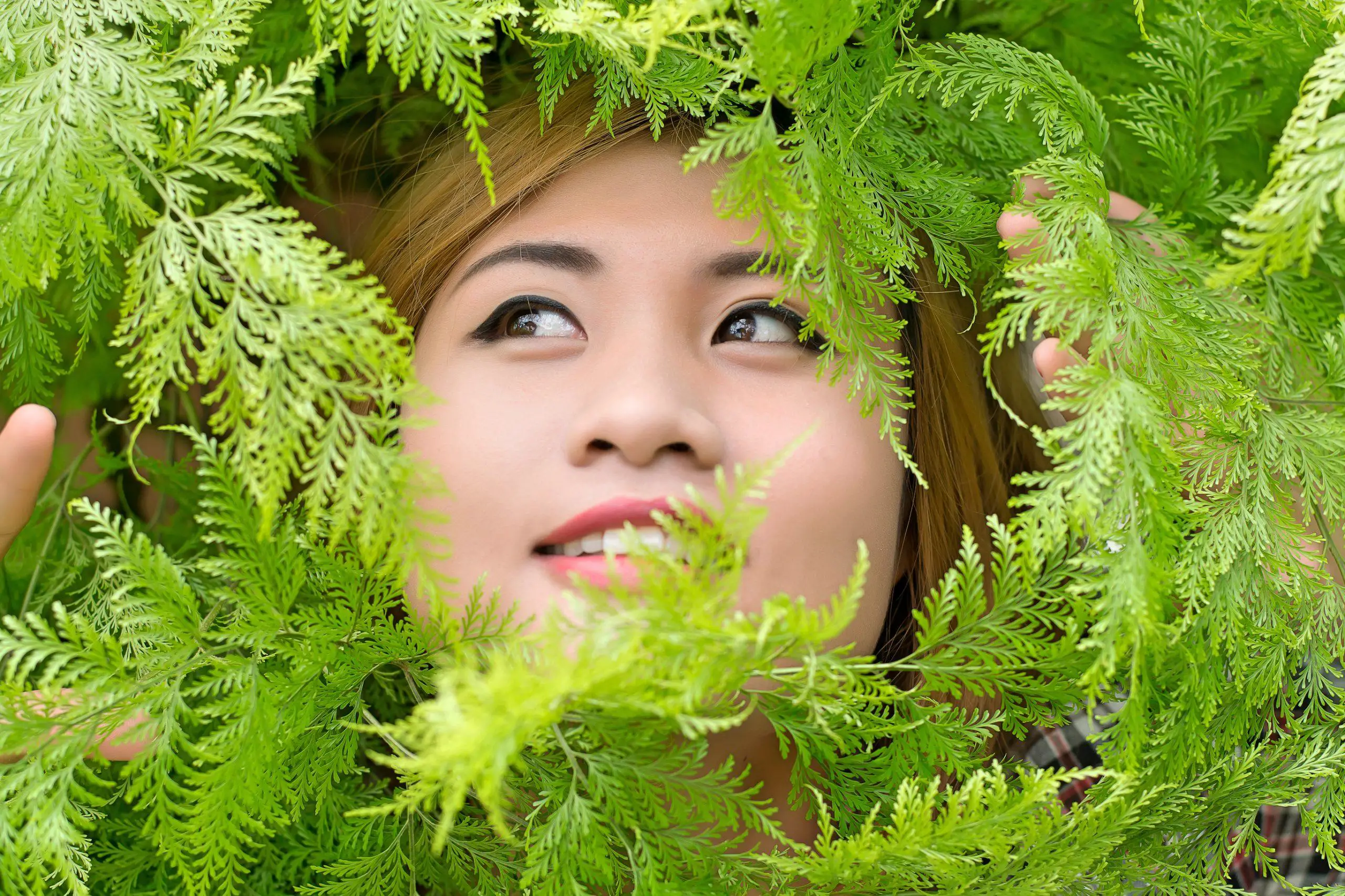 Woman looking through ferns