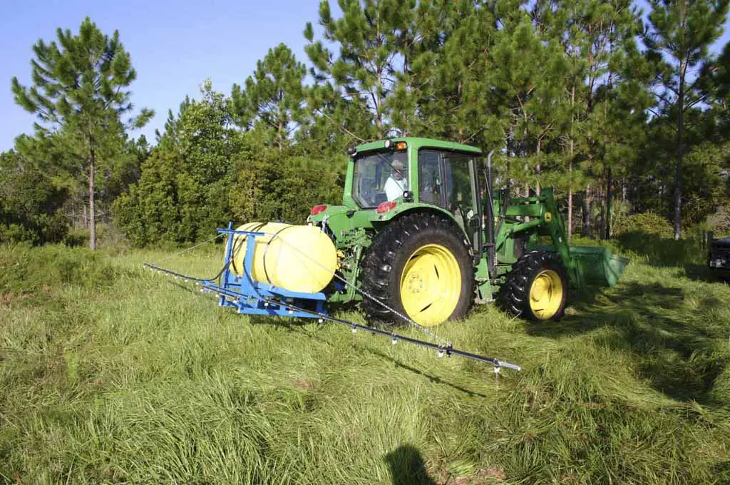 Farmer applying herbicide on scale to boost the crop yield